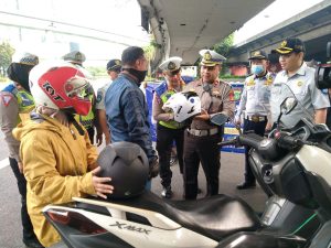 Operasi Patuh Jaya 2023, Satuan Lalulintas (Satlantas) Polres Metro Jakarta membagikan helm bagi pengendara roda dua yang taat berlalulintas