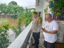 Antisipasi Banjir, Bhabinkamtibmas Kelurahan Senen Cek Debit Air Sungai